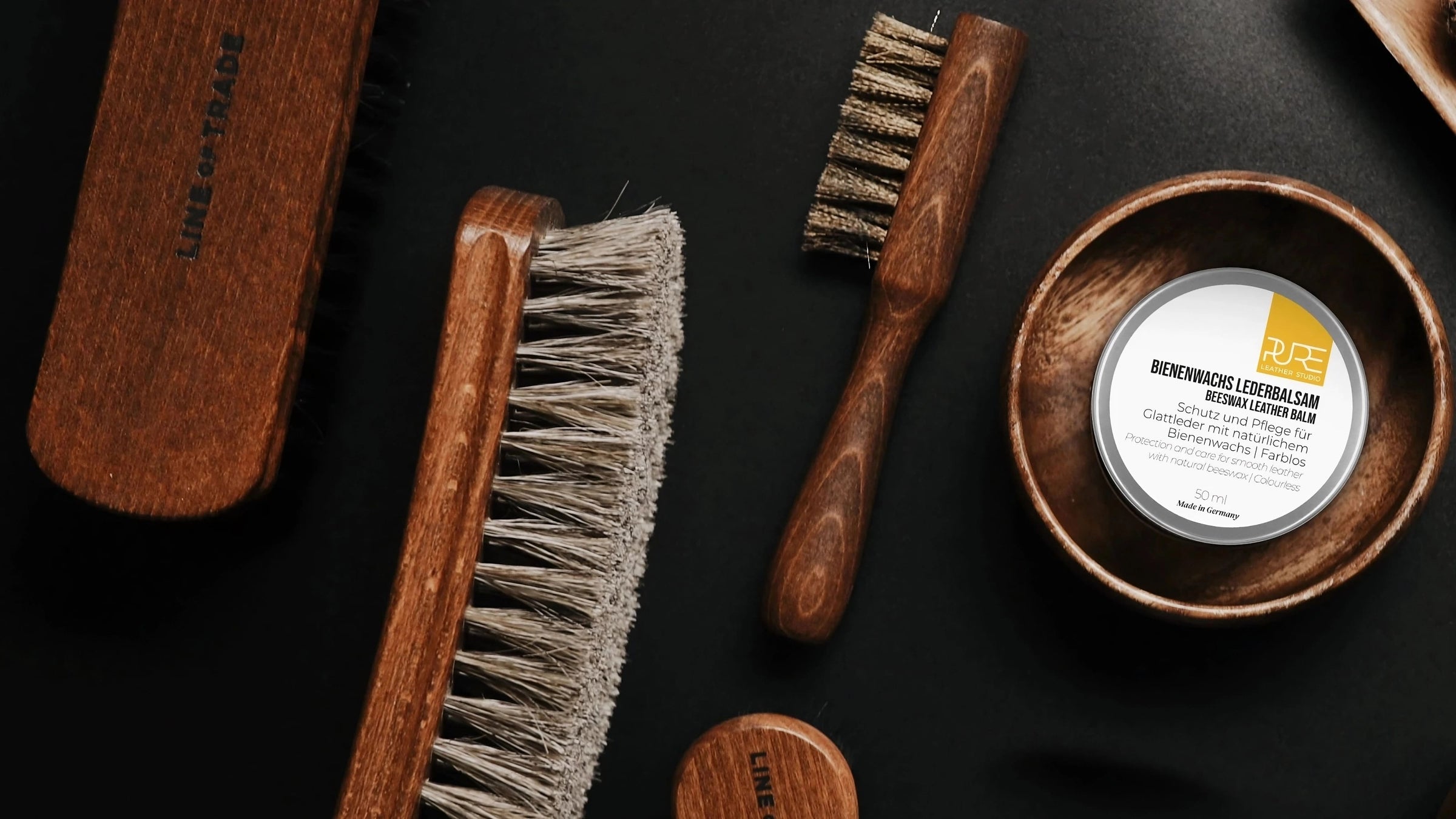 Lederpflege-Produkte von PURE mit Bienenwachs und Holzpflegebürste – natürlich für Glattleder-Taschen